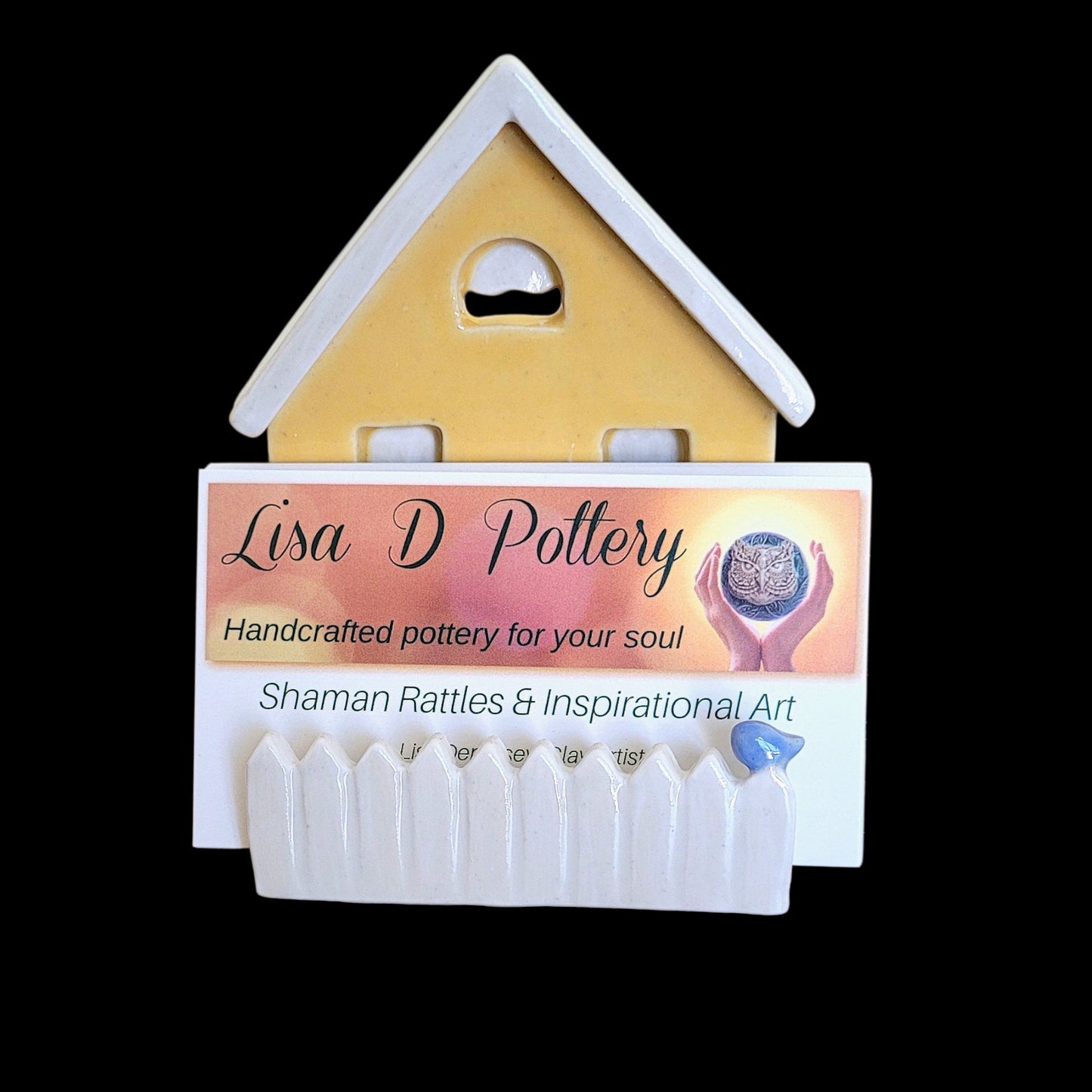 House-shaped business card holder with 'Lisa D Pottery' branding on a black background