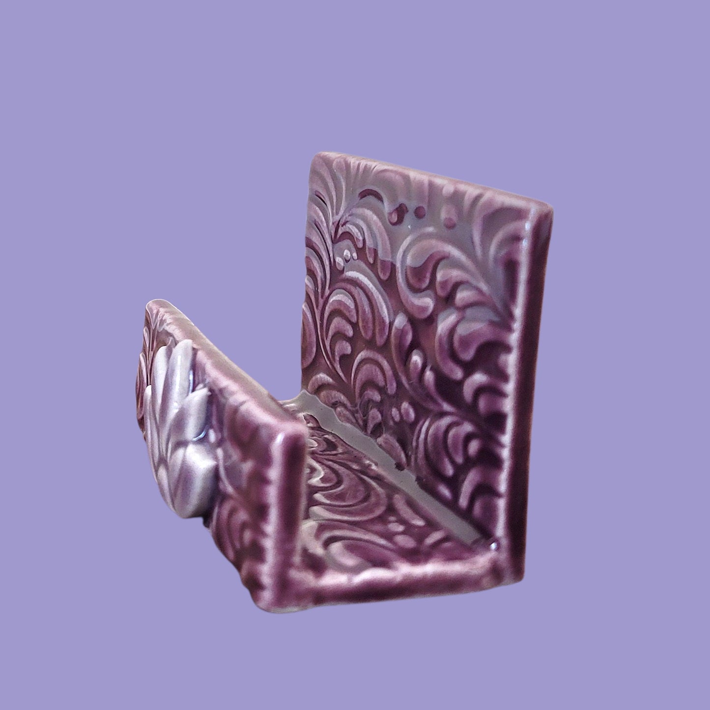 Purple and lavender business card holder with scroll patterns on a light purple background