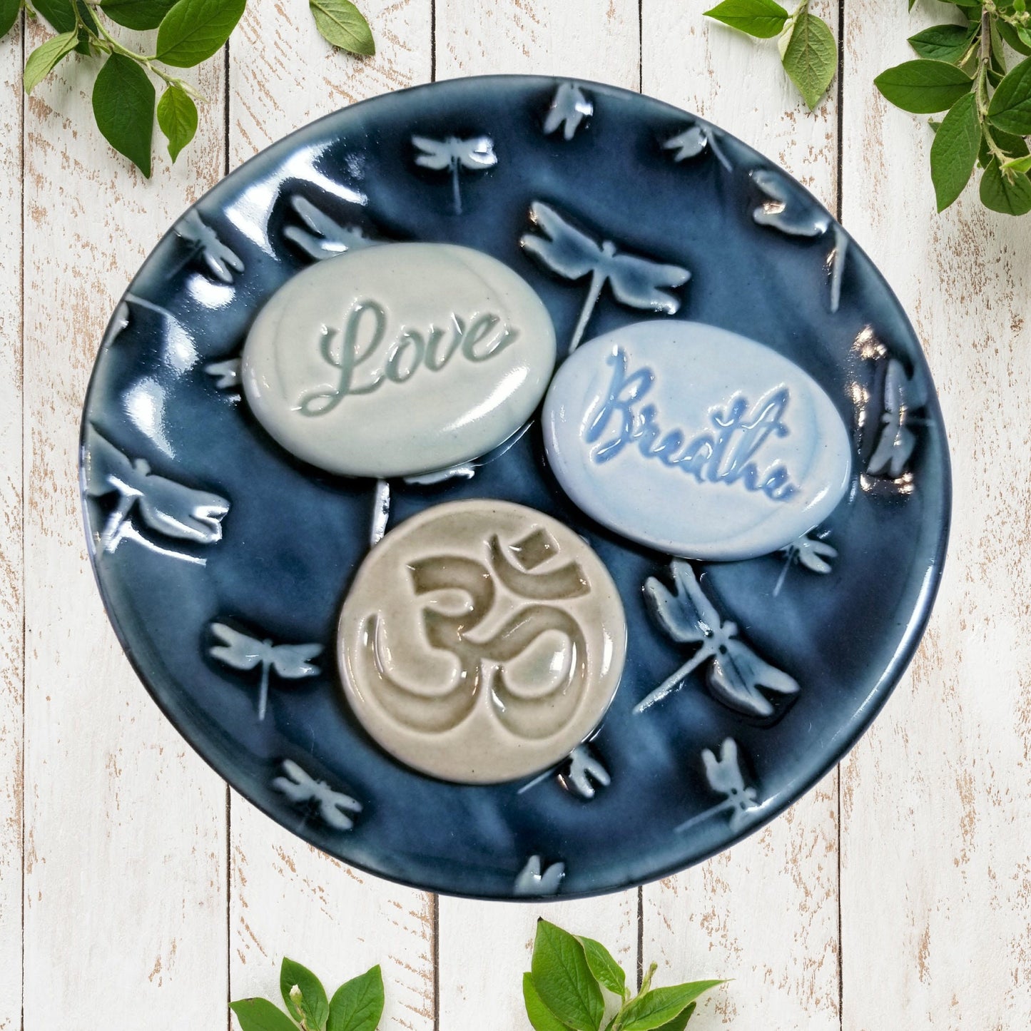 Close-up view of dragonfly design on handcrafted stoneware meditation dish showing glazed texture