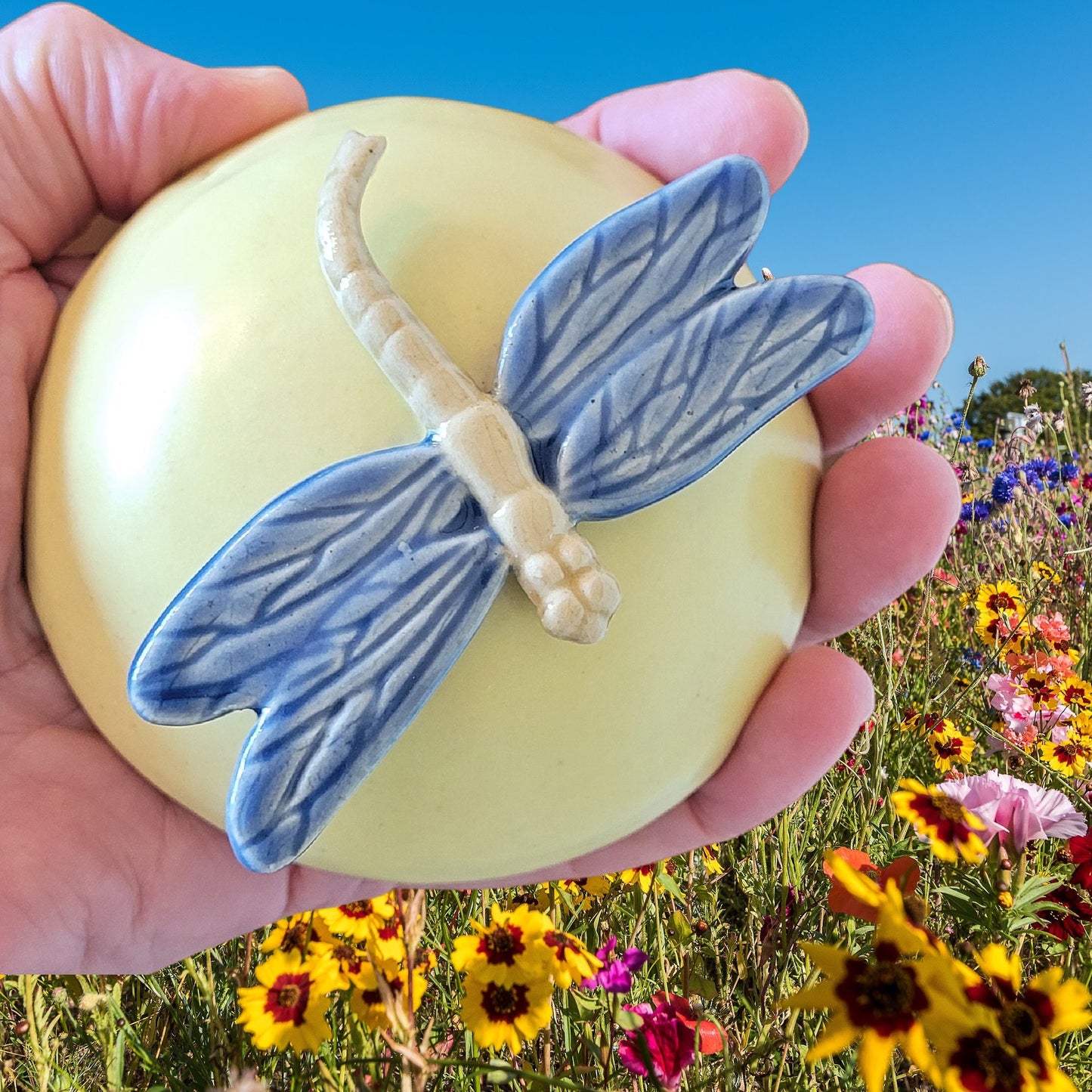 Handcrafted dragonfly meditation rattle held in hand showing size and ergonomic design for comfortable meditation use