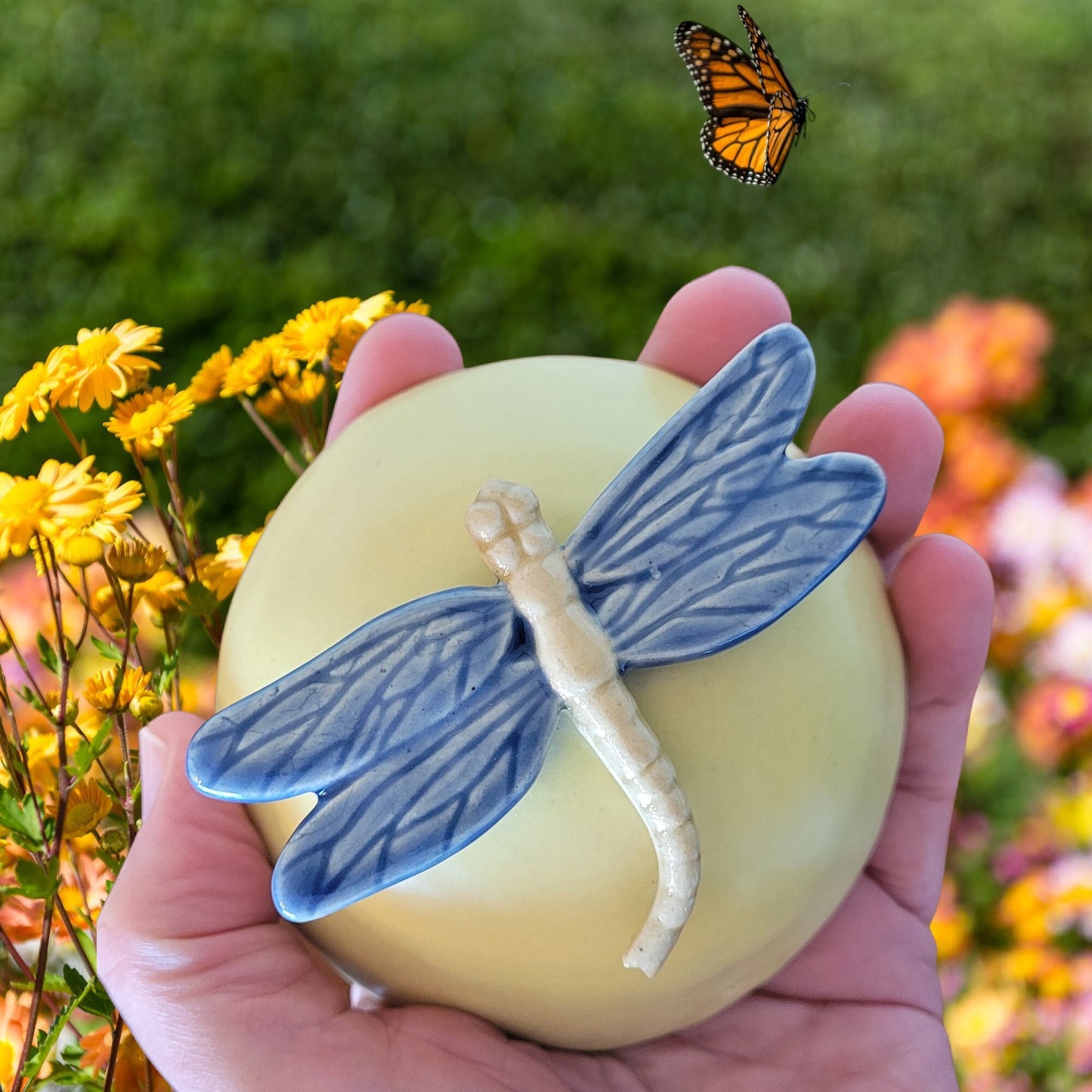 Close-up view of dragonfly meditation rattle displaying detailed ceramic relief work and wing artistry