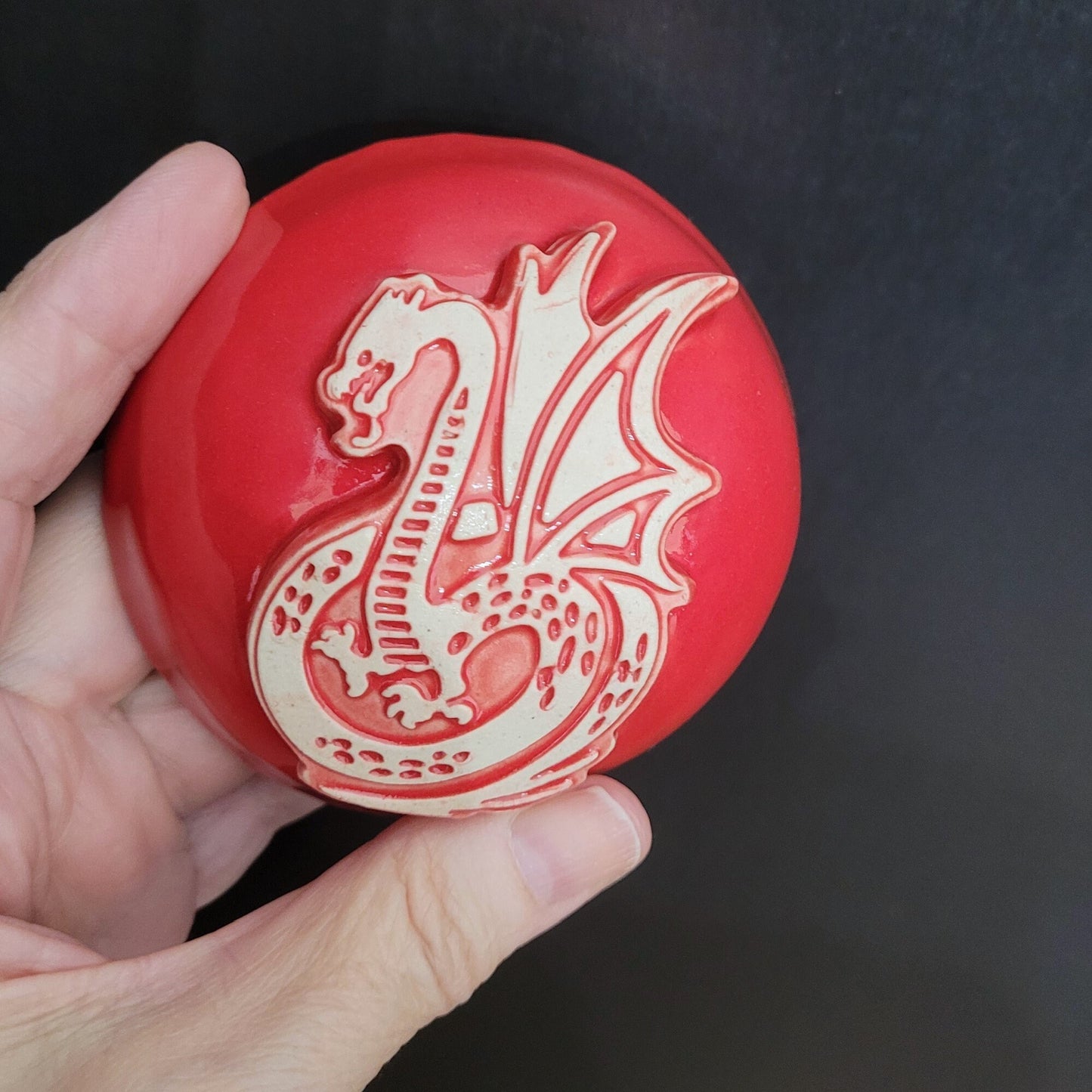 Handcrafted red dragon meditation rattle displaying the curved neck and body shape with kiln-fired ceramic finish
