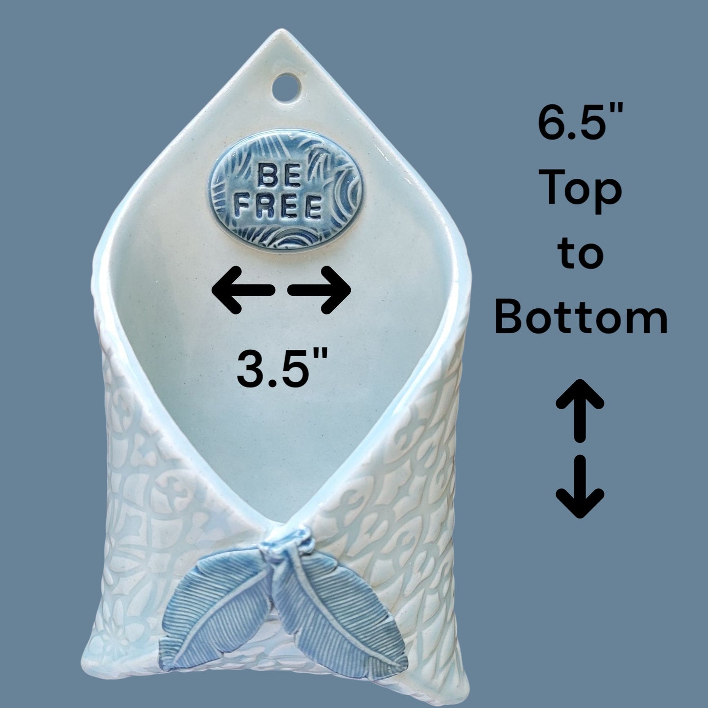 Decorative wall hanging with 'BE FREE' emblem and measurements on a blue background