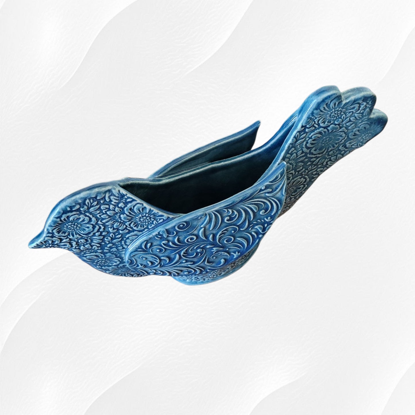 View from above blue ceramic bird-shaped planter on a white background