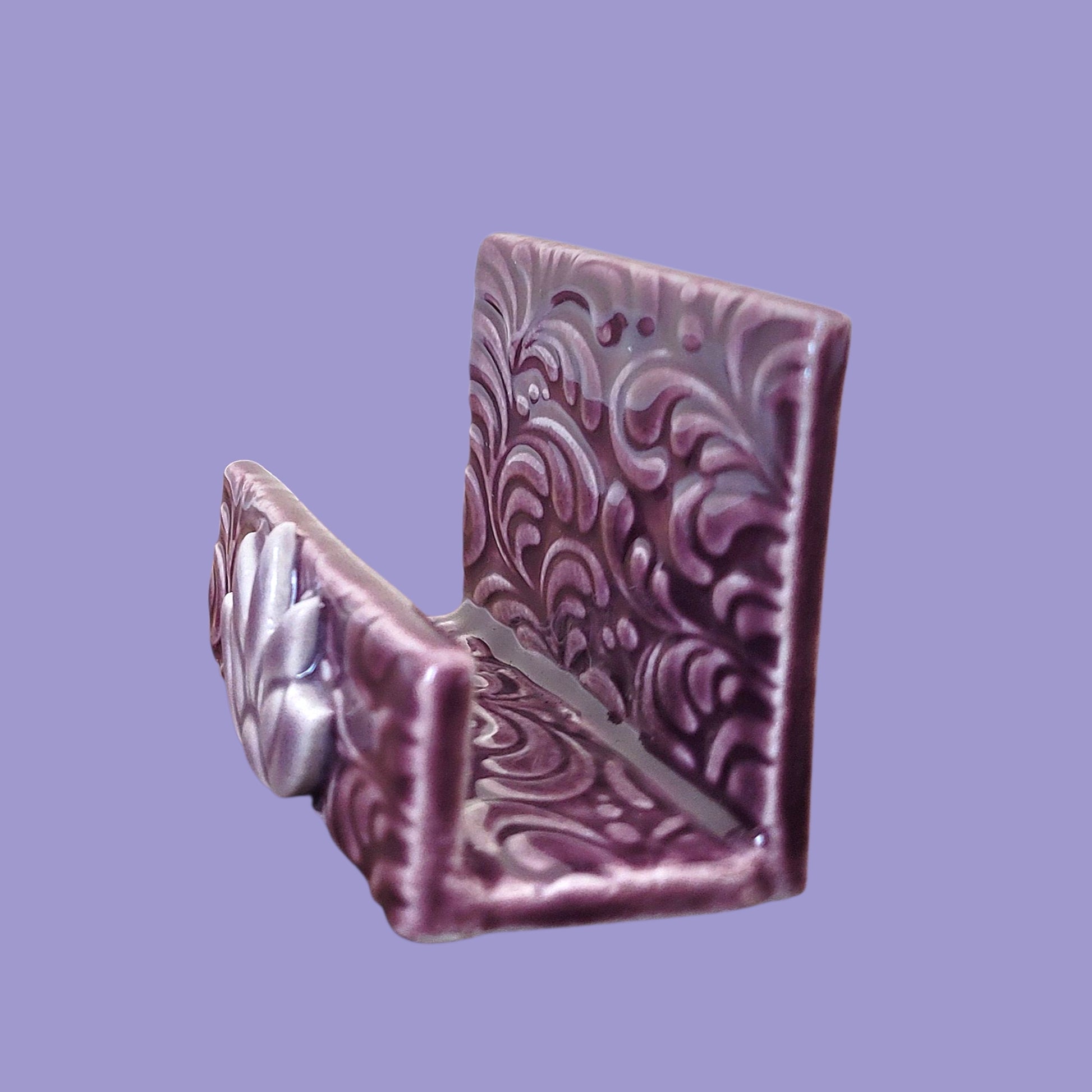 Purple and lavender business card holder with scroll patterns on a light purple background